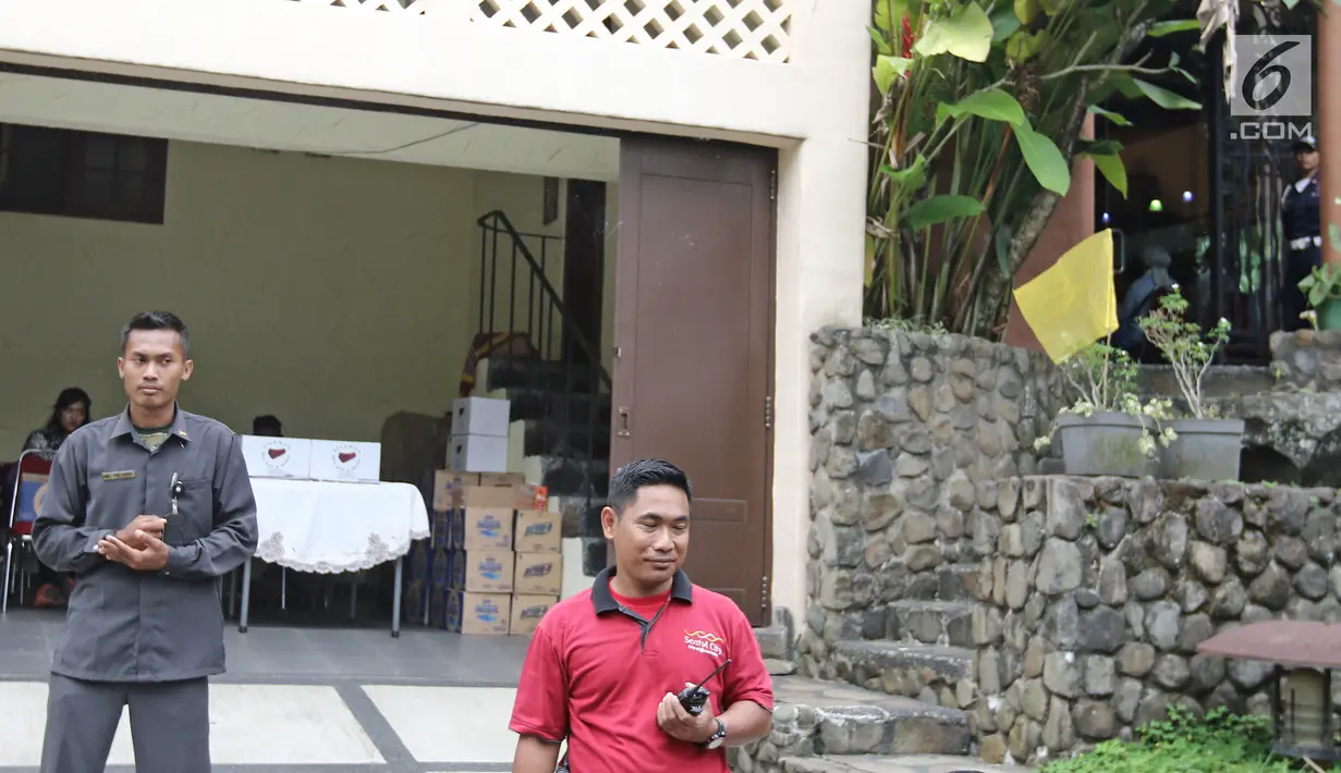 Seorang petugas keamanan berjaga di depan rumah duka pakar kuliner Bondan Winarno di Perumahan Sentul City, Bogor, Rabu (29/11). Seperti diketahui, Bondan meninggal dunia di RS Harapan Kita setelah mengalami gagal jantung. (Liputan6.com/Herman Zakharia)