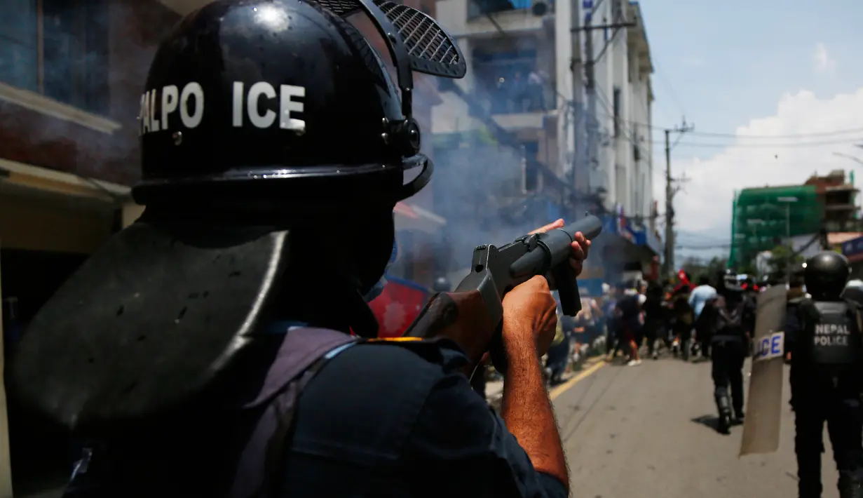 Polisi menembakkan meriam air dan gas air mata untuk membubarkan massa di Nepal (11/6/2020). Sekitar 1000 pemrotes berkumpul menuntut peningkatan pengujian dan dugaan korupsi oleh pejabat pemerintah saat membeli peralatan dan alat uji. (AP Photo/Niranjan Shrestha)