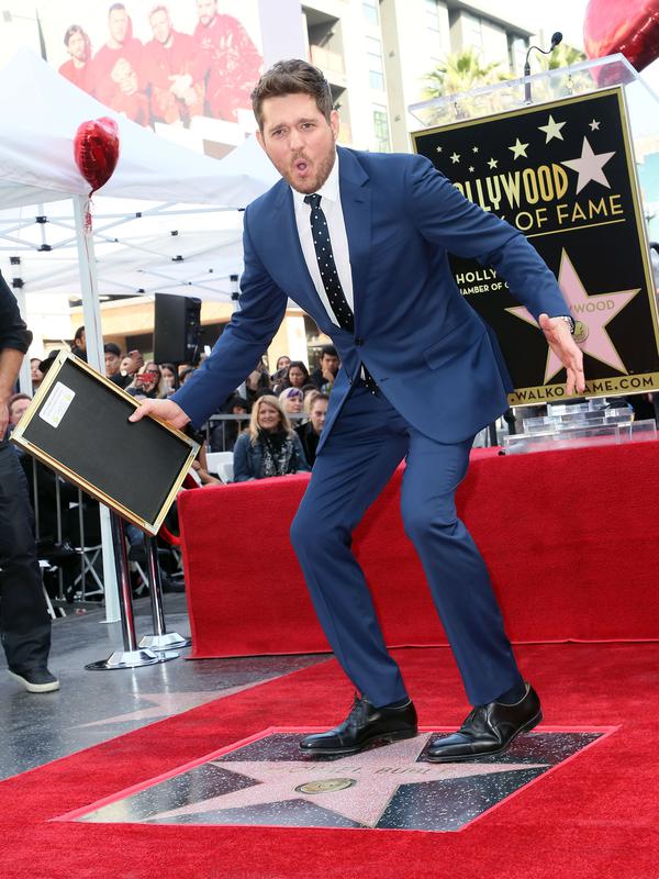 Michael Buble berpose di dekat bintang Hollywood Walk Of Fame miliknya saat acara penghargaan di Hollywood, California (16/11). Penyanyi Jazz asal Kanada ini merupakan penerima bintang ke 2,650 di Hollywood Walk Of Fame. (AFP Photo/David Livingston)