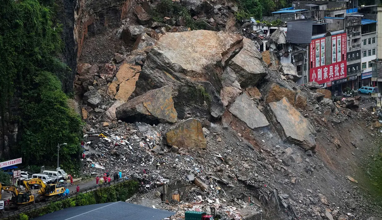 Kendaraan penyelamat bersiaga di jembatan saat tim penyelamat melakukan operasi pencarian dan penyelamatan di lokasi tanah longsor di Kabupaten Pengshui, Chongqing, Tiongkok barat daya, Sabtu, 18 Juli 2026. (AP Photo/Andy Wong)