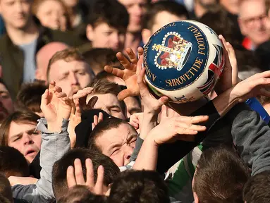 Para peserta berebut bola saat mengikuti Royal Shrovetide Football Match di Ashbourne, Derbyshire, Inggris, Selasa (5/3). Royal Shrovetide Football Match merupakan permainan sejenis sepak bola bercampur rugby. (Oli Scarff/AFP)