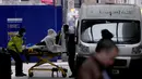 Seorang pasien didorong menggunakan troli di luar Rumah Sakit Royal London, Inggris, 6 Januari 2022. Inggris memangkas waktu isolasi pasien COVID-19 dari 10 menjadi 7 hari karena kekurangan tenaga kesehatan akibat lonjakan kasus yang dipicu Omicron. (AP Photo/Matt Dunham)