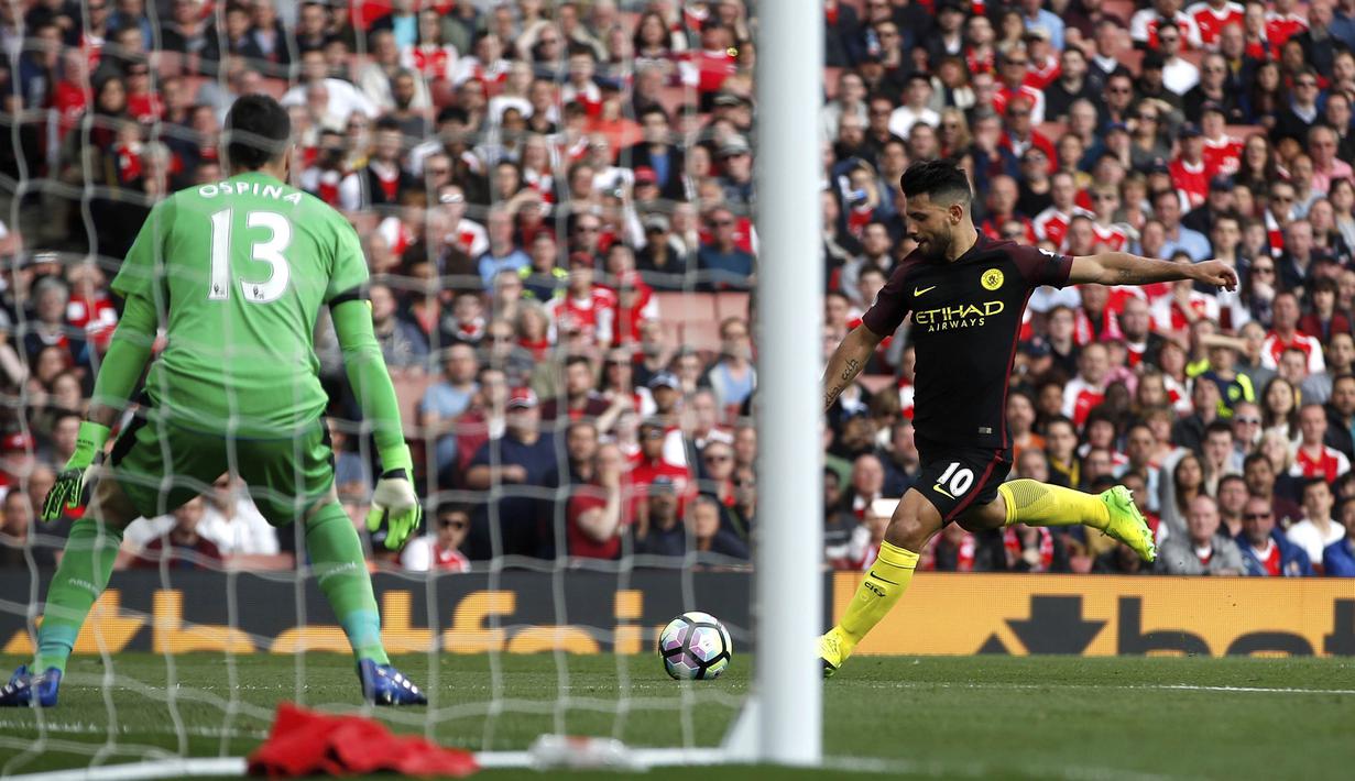 Striker Manchester City, Sergio Aguero, menendang bola ke arah gawang kiper Arsenal, David Ospina. Dalam laga tersebut, Manchester City sempat dua kali mengungguli tuan rumah. (AP/Alastair Grant)