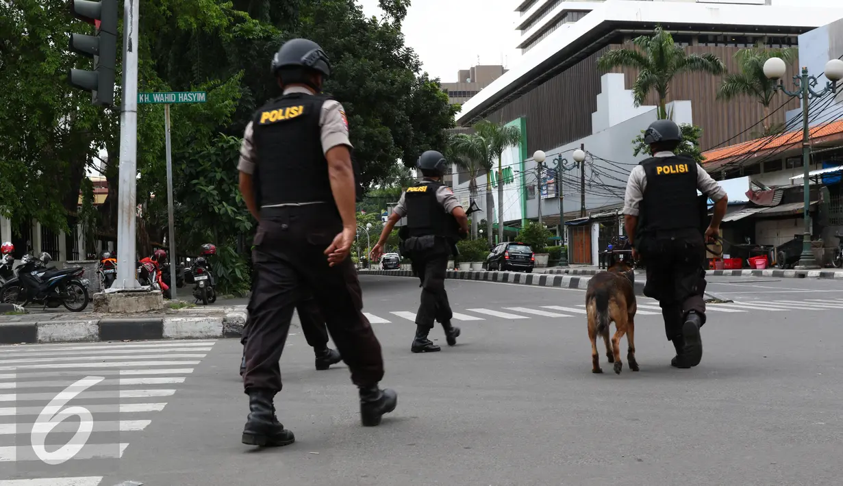 Personil kepolisian dengan anjing pelacak saat menyisir lokasi sekitar kejadian pengeboman, Jakarta, Kamis (14/1/2016). Beberapa ledakan dan suara senjata api terjadi di pusat ibukota. (Liputan6.com/Yudha Gunawan)