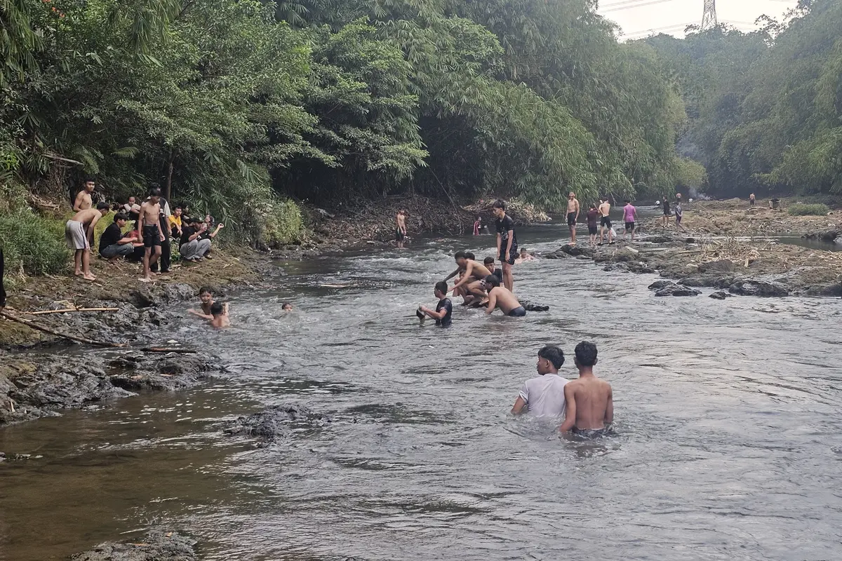 Sejumlah remaja memanfaatkan aliran sungai Ciliwung yang surut.