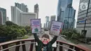Aktivis yang tergabung dalam Extintion Rebellion (XR) dan Walhi Jakarta melakukan aksi di JPO Pinisi, Jalan Jenderal Sudirman, Jakarta, Senin (14/11/2022). Aksi tersebut dilakukan untuk menyerukan kepada para pemimpin agar menghentikan “pencucian hijau” dan praktik ekonomi “business-as-usual” yang secara sistematis memperburuk krisis iklim dan mendorong umat manusia pada kehancuran ekologis & kepunahan massal. Negara-negara G20 turut menyumbang atas 80 persen emisi karbon dunia dan 60 persen populasi penduduk bumi. (Liputan6.com/Angga Yuniar)