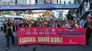 Peserta pawai mengenakan pakaian adat membentangkan spanduk saat festival Budaya Borneo di Car Free Day, Jakarta, Minggu (30/7). (Liputan6.com/Helmi Afandi)