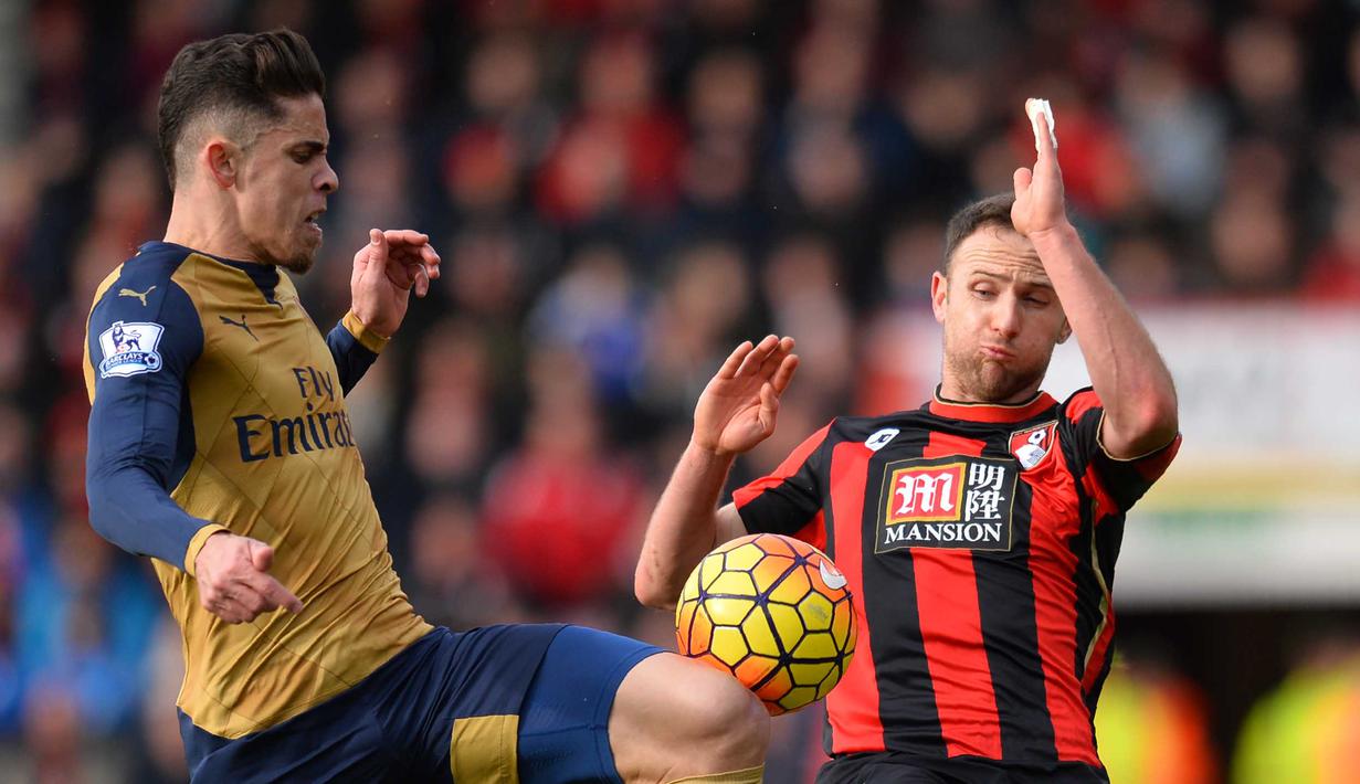 Pemain Arsenal, Gabriel (kiri) berebut bola dengan pemain AFC Bournemouth, Marc Pugh pada lanjutan liga Premier Inggris di Stadion Vitality, Minggu (7/2/2016). (AFP/Glyn Kirk)