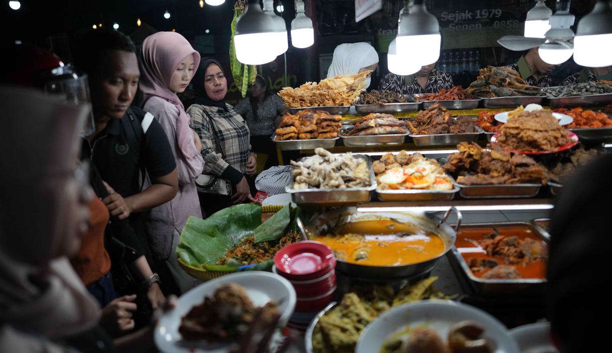 Sentra kuliner ini menyajikan berbagai makanan khas Sumatra Barat mulai dari makanan ringan hingga berat. Tampak dalam foto, orang-orang membeli makanan untuk berbuka puasa pada hari kedua bulan suci Ramadan 1447 Hijriah, di sebuah warung makan, Jakarta, Jumat 20 Februari 2026. (AP Photo/Dita Alangkara)