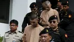 Dua tersangka pemboman Yusufu Mieraili dan Bilal Mohammed berjalan dikawal petugas saat meninggalkan Pengadilan militer (24/11). Pengadilan Thailand telah mendakwa dua orang yang dituduh melakukan serangan bom di Bangkok. (REUTERS /Chaiwat Subprasom)