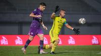 Kiper Persija Jakarta, Andritany Ardhiyasa (kanan) menendang bola dibayangi pemain Persita Tangerang, Ramiro Fergonzi pada laga lanjutan BRI Liga 1 2022/2023 di Stadion Indomilk Arena, Tangerang, Selasa (28/03/2023). (Bola.com/Bagaskara Lazuardi)