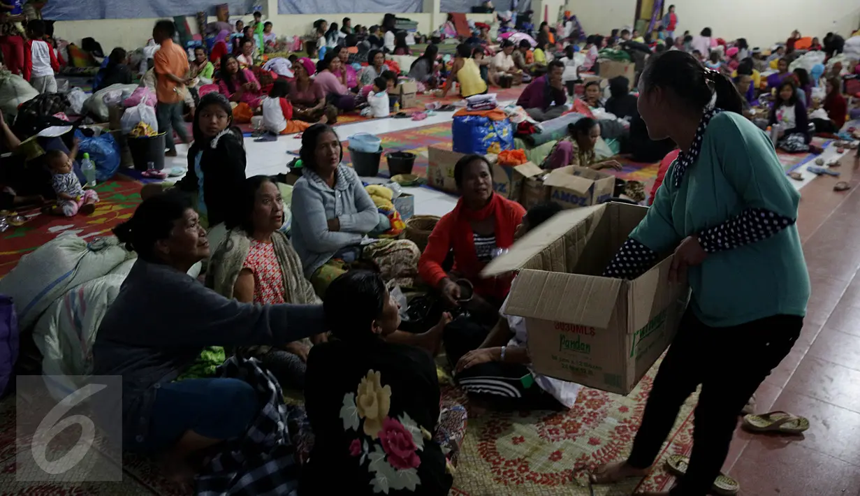 Seorang wanita membagikan makanan untuk berbuka kepada para pengungsi letusan Gunung Sinabung, Medan, Sabtu (4/7/2015). Pengungsi yang muslim tetap menjalankan puasa dengan menu sahur dan berbuka seadanya. (Liputan6.com/JohanTallo)