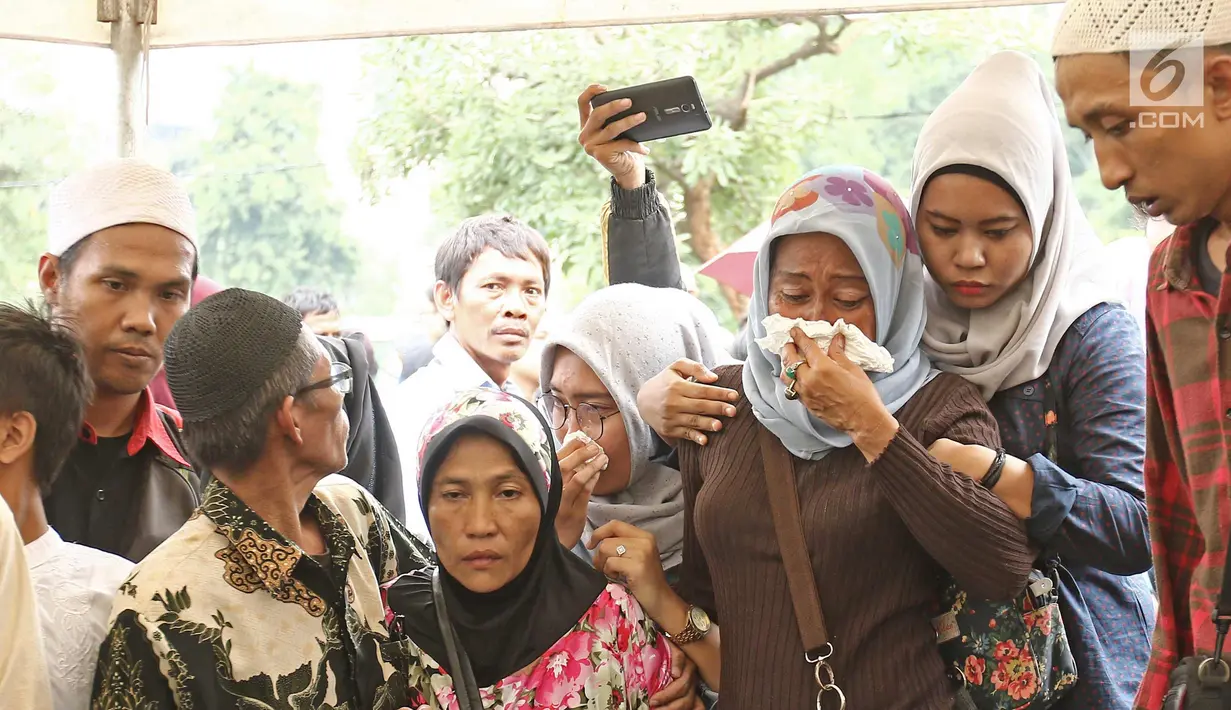 Kerabat dan keluarga menangis  saat  dipemakaman Laila Sari di Tempat Pemakaman Umum (TPU) Karet Bivak, Jakarta, Selasa (21/11). Laila Sari meninggal dunia saat pulang syuting, di usai 82 tahun. (Liputan6.com/Herman Zakharia)