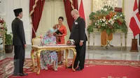 Ratu Denmark Margrethe II mengisi buku tamu disaksikan Presiden Jokowi (kiri) saat melakukan kunjungan kenegaraan di Istana Merdeka, Jakarta, Kamis (22/10). Pertemuan keduanya untuk mempererat hubungan kerja sama. (Liputan6.com/Faizal Fanani)