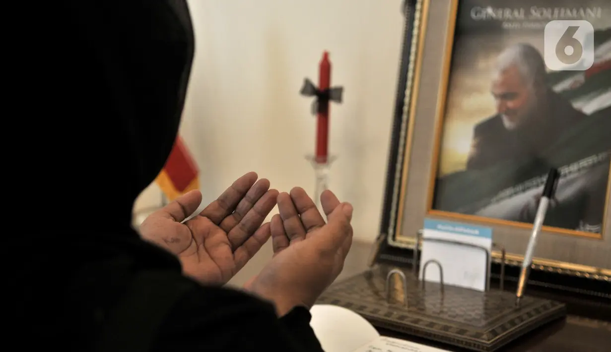 Warga berdoa usai menuliskan memo belasungkawa atas wafatnya Panglima Garda Revolusi Iran Jenderal Qasem Soleimanidi Kedutaan Besar Iran, Jakarta, Selasa (7/1/2020). (merdeka.com/Iqbal S. Nugroho)