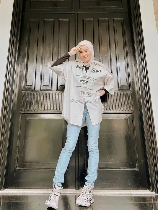 Tampilan kekinian Olla Ramlan dengan memadukan celana jeans dengan oversized shirt dan manset bisa kamu jadikan inspirasi. (Instagram/ollaramlan).