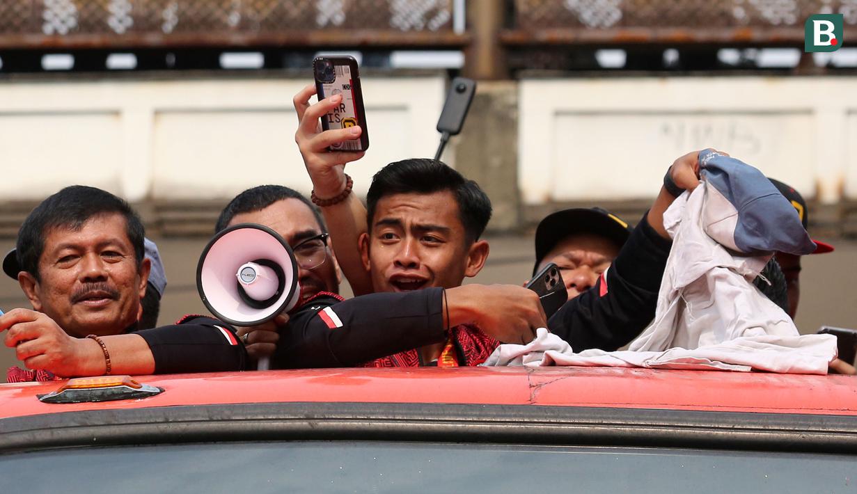 Reaksi pemain Timnas Indonesia U-22, Pratama Arhan saat tertimpuk seragam dari salah satu pelajar SMA Negeri 7 Jakarta Pusat saat pawai pawai bertajuk Kira87uara Kontingen SEA Games 2023 yang berlangsung dari Kemenpora hingga Stadion Utama Gelora Bung Karno (SUGBK), Senayan, Jakarta, Jumat (19/5/2023). Acara tersebut merupakan bentuk perayaan keberhasil kontingen Indonesia yang telah melampaui target medali emas di SEA Games 2023 dan kesuksesan Timnas Indonesia U-22 yang telah mengakhiri puasa gelar 32 tahun di SEA Games 2023. (Bola.com/Bagaskara Lazuardi)
