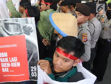 Seorang mahasiswa yang tergabung dalam Kesatuan Aksi Mahasiswa Muslim Indonesia (KAMMI) Bogor menunjukkan poster saat melakukan aksi di Jalan Ir. H.Djuanda, Bogor (29/03). Dalam akisnya mereka menolak harga kenaikan BBM. (Merdeka.com/Arie Basuki)
