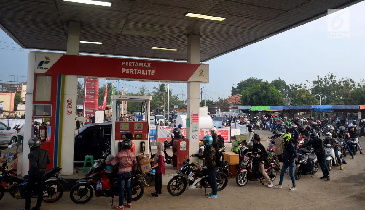 Pemudik sepeda motor mengantre BBM di SPBU Tulungangung, Indramayu, Jabar, Jumat (23/6). Tingginya volume kendaraan pemudik yang masuk membuat antrian menjadi panjang. (Liputan6.com/Johan Tallo)
