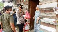 Irwasda Polda Riau Kombes Hermansyah SIK membagikan sembako kepada warga terdampak Covid-19. (Liputan6.com/M Syukur)