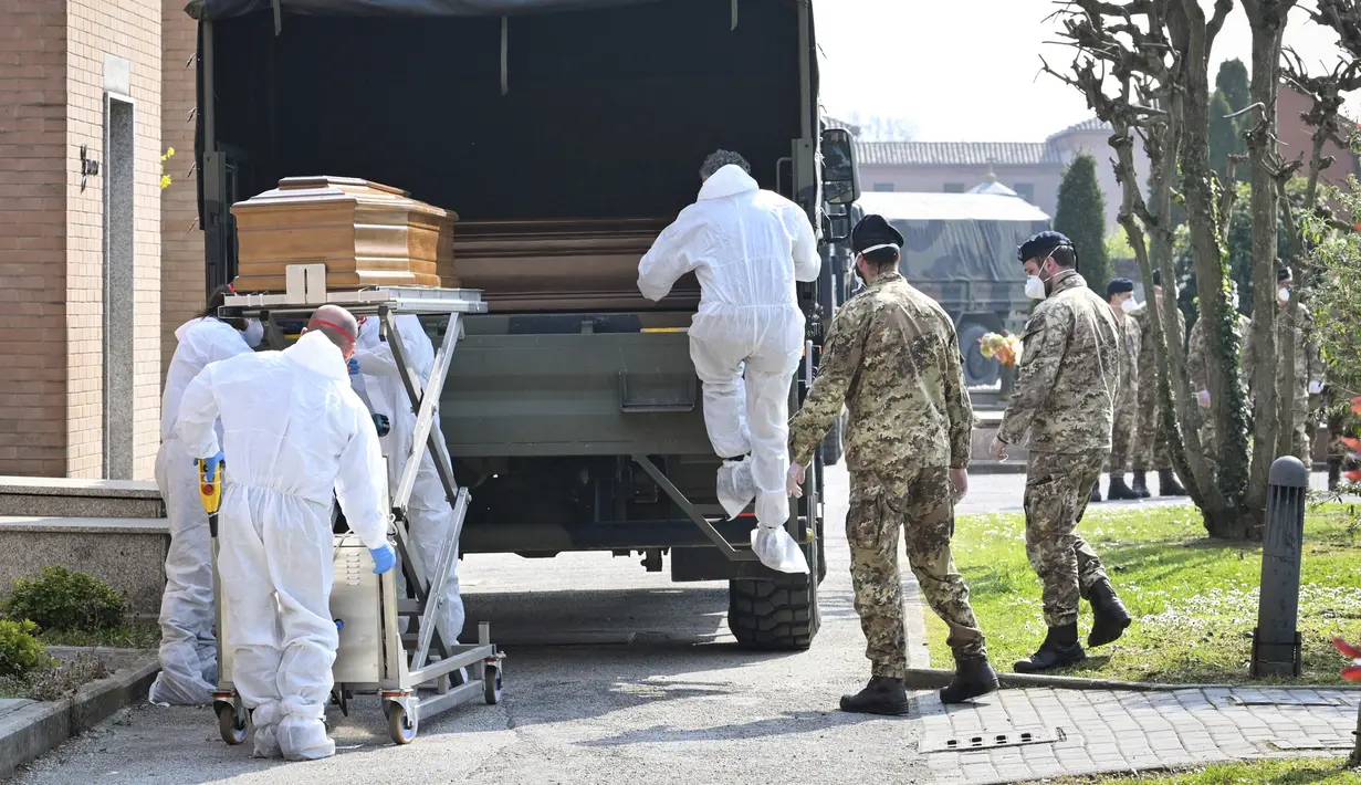 Petugas membawa peti mati berisi jasad korban virus corona COVID-19 yang diturunkan dari truk militer di pemakaman Ferrara, Italia, Sabtu (21/3/2020). Dari mereka yang awalnya terinfeksi COVID-19 secara nasional, 6.072 orang telah dinyatakan pulih sepenuhnya. (Massimo Paolone/LaPresse via AP)