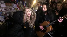 Penyanyi Madonna (tengah) bernyanyi di samping gitarisnya Monte Pittman (tengah kanan) dan anaknya David Banda (kiri) di place de la Republique di Paris untuk mengenang korban serangan teror 13 November di Paris, Kamis (10/12/2015). (JULES MAHE/AFP)