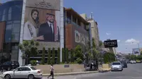 Sebuah poster bergambar Putra Mahkota Yordania Hussein dan tunangannya, arsitek Saudi Rajwa Alseif digantung di depan sebuah gedung di Amman, Yordania, Selasa, 30 Mei 2023. (AP Photo/Nasser Nasser)