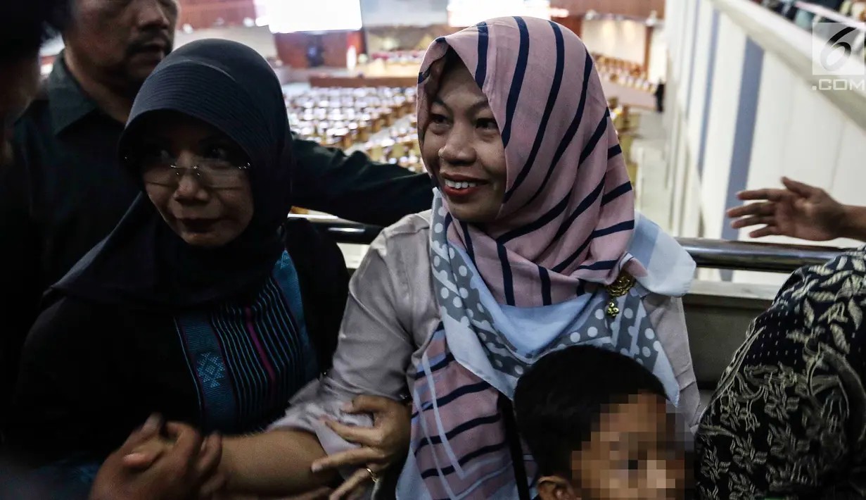 Terpidana kasus dugaan pelanggaran UU ITE sekaligus korban pelecehan seksual Baiq Nuril menerima selamat dari beberapa orang saat DPR menyetujui amnesti untuk dirinya dalam rapat paripurna DPR di Kompleks Parlemen Senayan, Jakarta, Kamis (25/7/2019). (Liputan6.com/JohanTallo)