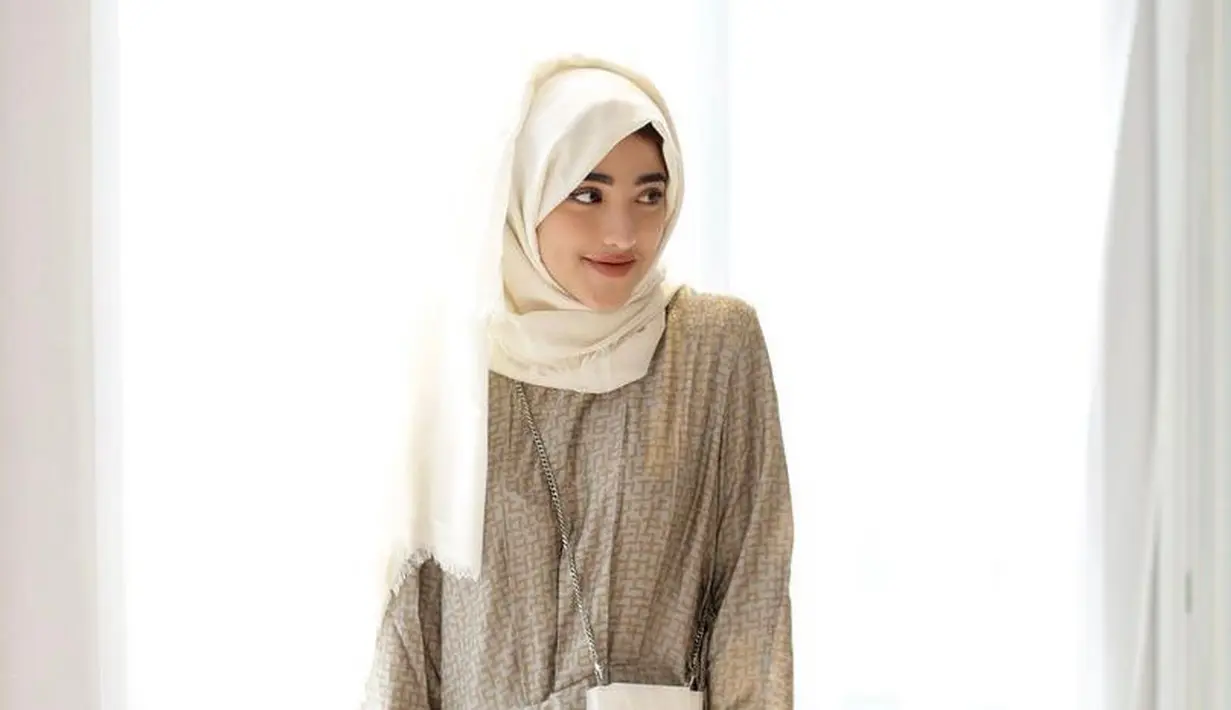 <p>Untuk outfit lebaran, bisa pilih gamis warna nude yang dipadukan dengan hijab pashmina warna putih tulang seperti look influencer Shirin Al-Athrus ini (Instagram/shireeenz).</p>