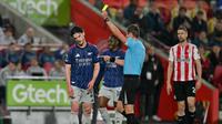 Wasit John Brooks memberikan kartu kuning kepada gelandang Arsenal, Declan Rice, pada pertandingan Liga Inggris 2025/2026 melawan Brentford di Gtech Community Stadium, London, Jumat (13/1/2026) dini hari WIB. (Glyn Kirk/AFP)