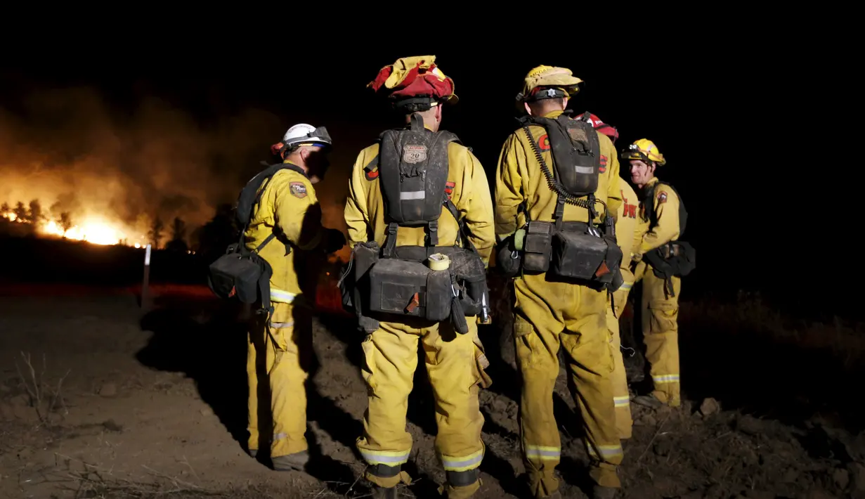 Petugas pemadam kebakaran bersiap memadamkan api di hutan kawasan California, AS, Senin (3/8/2015). Sedikitnya 9.000 petugas damkar berjuang mengatasi sebanyak 18 kebakaran hutan yang melanda Negara Bagian California, AS. (Reuters/ Stephen Lam) 