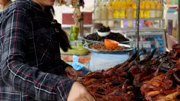 Pedagang menyiapkan tikus bakar untuk pelanggannya di provinsi Battambang, Kamboja (8/8/2019). Tikus bakar yang lebih besar dijual dengan harga 1,25 USD atau sekitar 17000 ribu rupiah. (AFP Photo/Tang Chhin Sotthy)