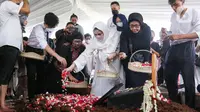 Nia Zulkarnaen (ketiga kanan), putri aktris senior Mieke Wijaya, menaburkan bunga di atas makam sang ibunda di TPU Tanah Kusir, Jakarta, Rabu (4/5/2022). Mieke Wijaya meninggal dunia pada Selasa, 3 Mei 2022 di Jakarta. Ia meninggal dunia pada usia 82 tahun. (Liputan6.com/Herman Zakharia)