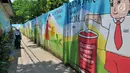 Pemandangan sebuah gang yang dihiasi warna-warni mural di Kelurahan Rorotan, Jakarta, Kamis (29/3). Setiap tembok gang sepanjang 100 meter tersebut dihiasi dengan berbagai mural atau gambar kartun inspiratif. (Merdeka.com/Iqbal S Nugroho)
