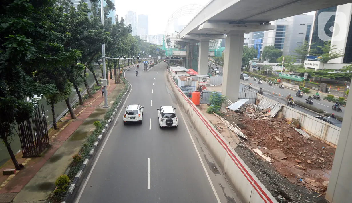 Kendaraan melintas di Jalan Rasuna Said, Jakarta, Senin (16/3/2020). Jalan Rasuna Said terlihat lengang setelah Gubernur DKI Jakarta Anies Baswedan mencabut sementara sistem ganjil genap dan meliburkan sekolah untuk mengantisipasi penyebaran virus corona COVID-19. (merdeka.com/Dwi Narwoko)