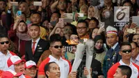 Presiden Joko Widodo saat menyalakan api obor Asian Games 2018 sebelum upacara penurunan Bendera Merah Putih di Istana Negara Jakarta, Jumat (17/8). (Liputan6.com/Pool/Eko)