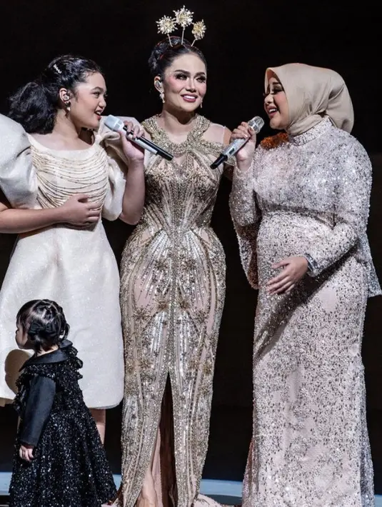 Saat konser Krisdayanti, Aurel tampil mengenakan dress yang diperindah dengan payetan. Cocok dengan kerudung coklatnya.  [@krisdayantilemos]