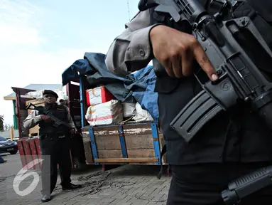 Petugas berjaga dibelakang truk penyelundupan barang asal impor melalui jalur interseluler di Polres Pelabuhan Tanjung Priok, Jakarta, Senin (23/11). Polres Pelabuhan berhasil mengamankan 298 koli muatan dari KM UMSINI. (Liputan6.com/Immanuel Antonius)