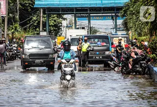 Kendaraan bermotor melintasi jalan yang tergenang air rob (banjir pasang air laut) di Kawasan Pasar Ikan Muara Baru, Jakarta, Kamis (4/6/2020). Banjir rob di Pelabuhan Muara Baru tersebut terjadi akibat cuaca ekstrem serta pasangnya air laut. (Liputan6.com/Faizal Fanani)