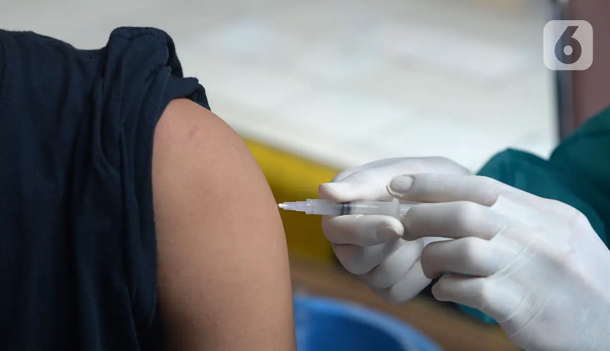 Pedagang disuntik vaksin virus corona COVID-19 di Pasar Induk Kramat Jati, Jakarta Timur, Kamis (22/7/2021). Sebanyak 250 pedagang Pasar Induk Kramat Jati menjalani vaksinasi guna menekan penyebaran COVID-19. (merdeka.com/Imam Buhori)
