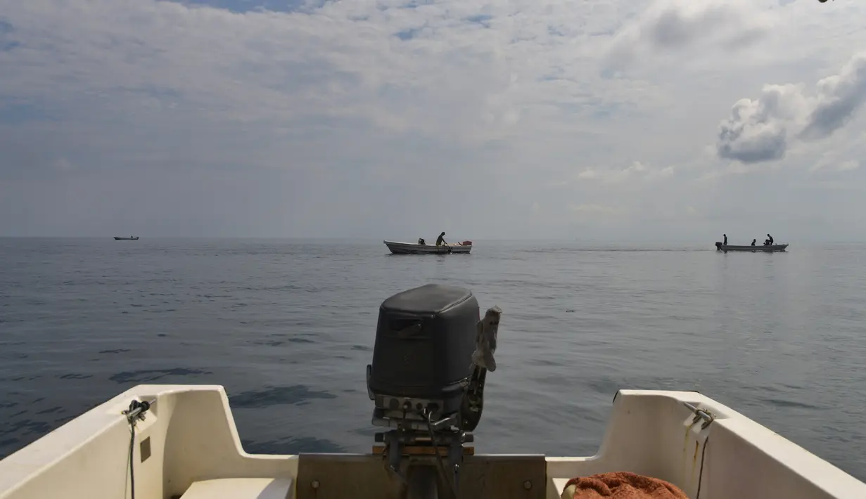 Kapal menyeberangi perairan situs penyelaman di Iboih, pantai populer dan taman wisata di seberang teluk dari Sabang di pulau Weh, provinsi Aceh (6/10/2019). (AFP Photo/Chaideer Mahyuddin)