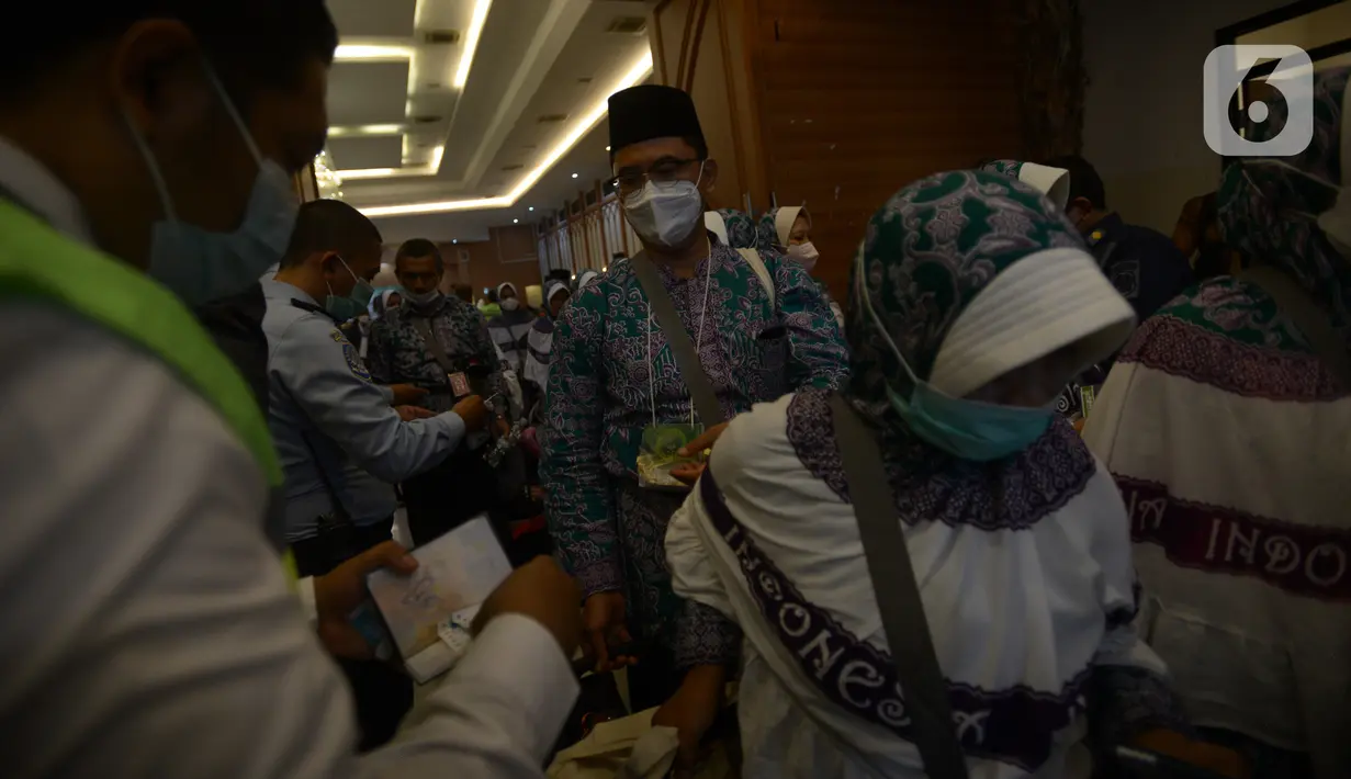Jemaah calon haji kelompok terbang (kloter) 1 embarkasi haji Jakarta - Pondok Gede bersiap berangkat menuju Bandara Soekarno - Hatta di Asrama Haji Pondok Gede, Jakarta, Sabtu (4/6/2022) dini hari. Sebanyak 389 calon haji asal DKI Jakarta yang tergabung dalam kloter 1 embarkasi haji Jakarta - Pondok Gede diberangkatkan menuju tanah suci Arab Saudi melalui Bandara Internasional Soekarno - Hatta. (merdeka.com/Imam Buhori)