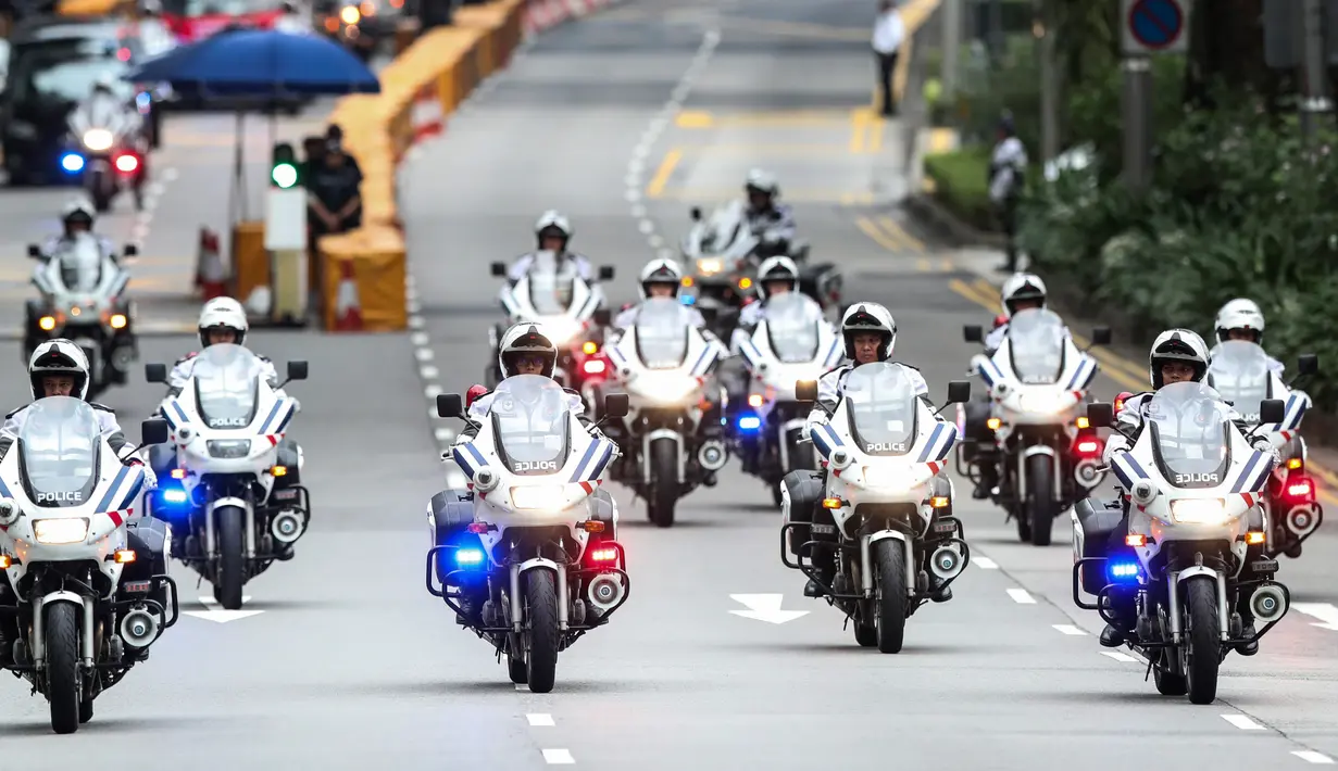Petugas polisi memimpin iring-iringan mobil pemimpin Korea Utara Kim Jong-un meninggalkan Hotel St. Regis, Singapura, Selasa (12/6). Kim dan Presiden AS Donald Trump akan bertemu dalam KTT Korea Utara-AS di Hotel Capella, Pulau Sentosa. (AP/Yong Teck Lim)