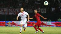 Gelandang Timnas Indonesia, Riko Simanjuntak, berebut bola dengan gelandang Vietnam, Nguyen Quang Hai, pada laga Kualifikasi Piala Dunia 2022 di Stadion Kapten I Wayan Dipta, Bali, Selasa (15/10). Indonesia kalah 1-3 dari Vietnam. (AFP/Aditya Wany)