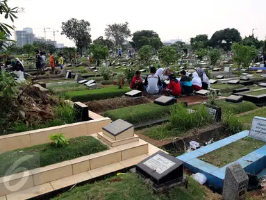 Umat muslim berdoa di makam keluarganya di TPU Karet Bivak, Jakarta, Minggu (14/6/2015). Menjelang bulan Ramadan, umat muslim melakukan ziarah kubur untuk mendoakan keluarga dan kerabatnya yang telah wafat. (Liputan6.com/Helmi Afandi)