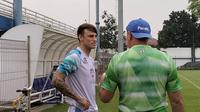 Kiper baru Persib Bandung, Kevin Ray Mendoza Hansen (kiri), berbincang dengan pelatih Bojan Hodak saat sesi latihan tim. (Bola.com/Erwin Snaz)