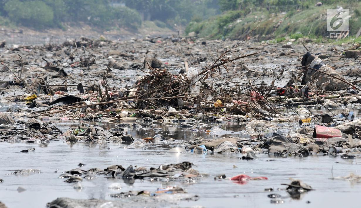 Tumpukkan sampah yang muncul di permukaan Kanal Banjir Barat, Jakarta, Selasa (16/7/2019). Kemarau sejak dua bulan terakhir ini menyebabkan sampah-sampah yang mengendap di dasar sungai muncul ke permukaan sehingga menimbulkan bau tak sedap. (merdeka.com/Iqbal S Nugroho)