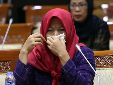 Terpidana kasus pelanggaran UU ITE sekaligus korban pelecehan seksual Baiq Nuril menangis saat hadir dalam rapat pleno Komisi III DPR di Gedung Nusantara III, Jakarta, Rabu (23/7/2019). Rapat membahas surat pertimbangan amnesti dari Presiden Joko Widodo. (Liputan6.com/JohanTallo)