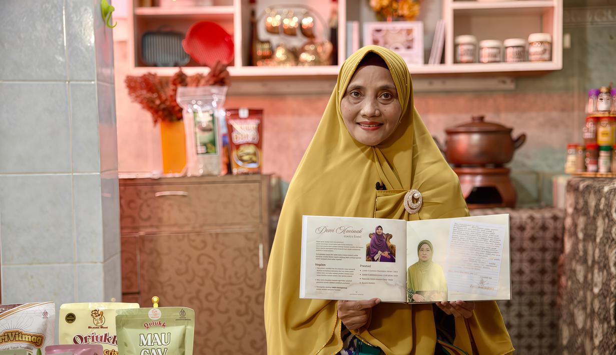 Dewi Aminah, pendiri Iswara Food, berdiri di depan rak produknya yang rapi tersusun di ruang produksi rumahnya di Solo. Usaha ini ia rintis setelah kehilangan bisnis batik akibat kebakaran di Pasar Klewer. (Adv/BRI)