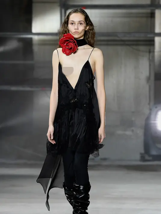Seorang model mengenakan gaun rancangan Yves Saint Laurent ready-to-wear dalam peragaan busana di Paris, 28 Februari 2017. Gaun model tersebut melorot saat menampilkan koleksi Fall-Winter 2017-2018. (AP/Francois Mori)